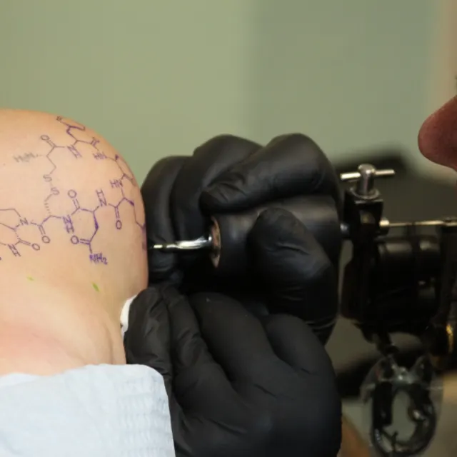 Tatuador de luvas durante uma sessão